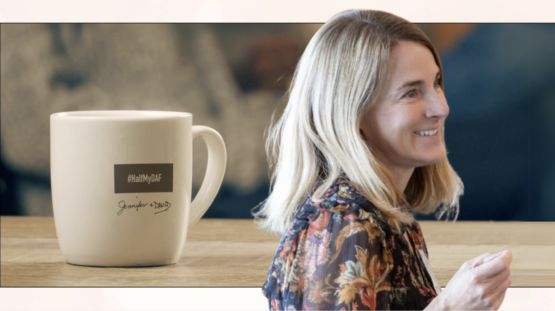 A woman standing in the foreground wearing a printed blouse with an image of a cup on table that says Half My DAF.